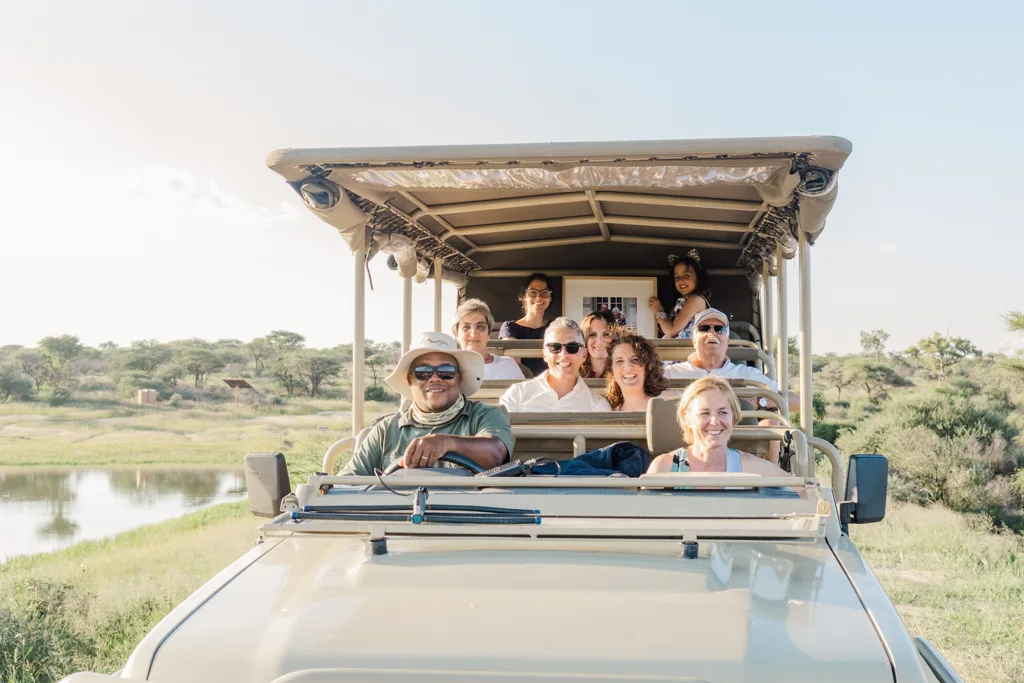 Guests on an open safari vehicle during a game drive at Okonjima, Namibia