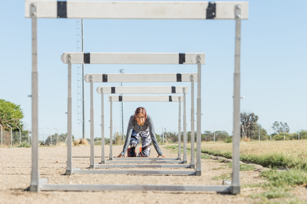 girl in starting block, view through rows of hurdles, matric portrait session by mariette du toit photography