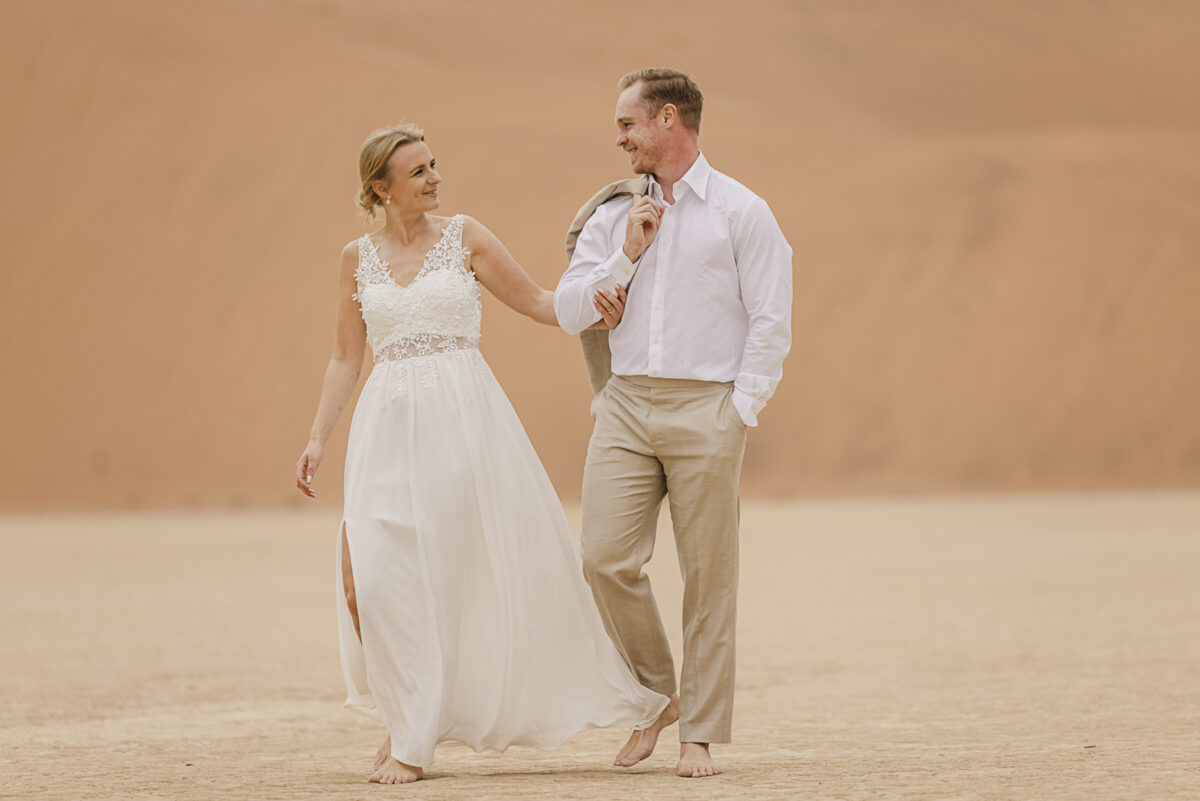 Romantic couple’s portrait against the muted tones of the Namib Desert dunes on an overcast day