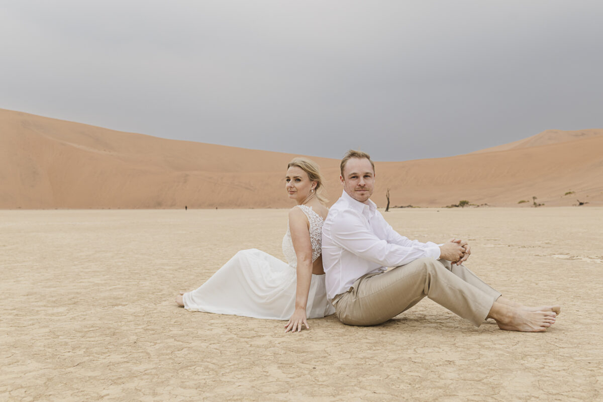 Romantic couple’s portrait against the muted tones of the Namib Desert dunes on an overcast day