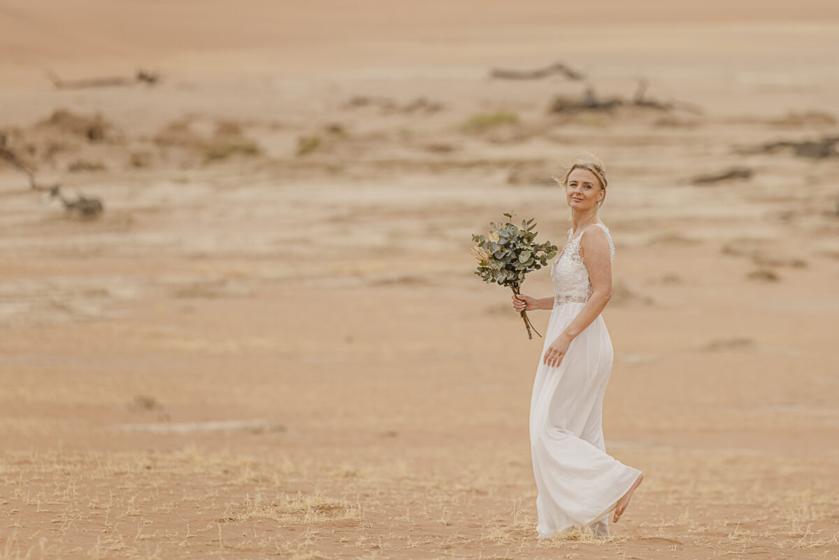 Bridal portrait against the muted tones of the Namib Desert dunes on an overcast day, image by Mariette du toit Photography