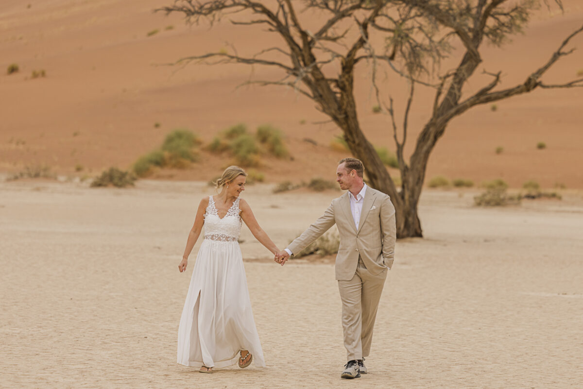 Romantic couple’s portrait against the muted tones of the Namib Desert dunes on an overcast day