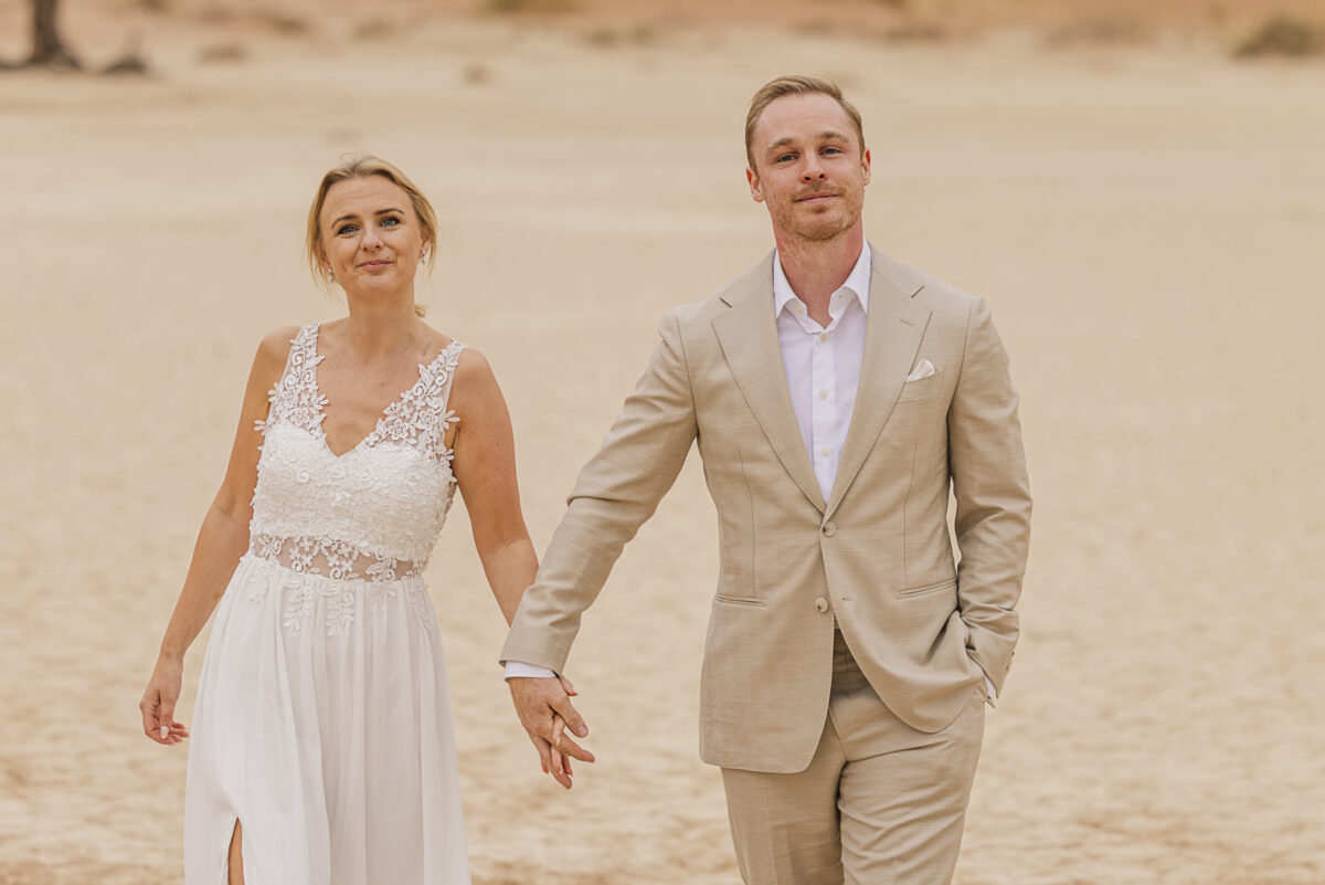 Romantic couple’s portrait against the muted tones of the Namib Desert dunes on an overcast day