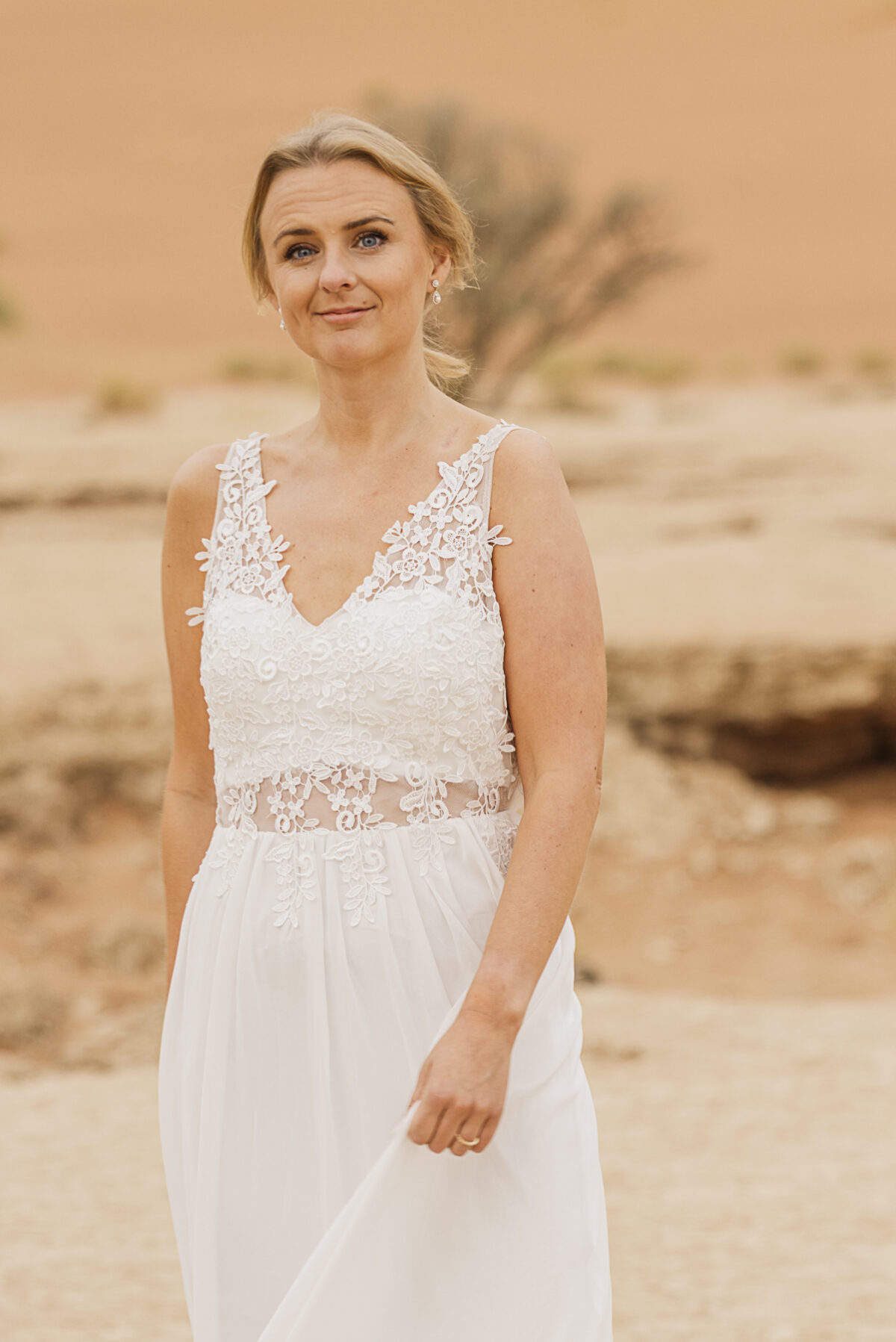 Bridal portrait against the muted tones of the Namib Desert dunes on an overcast day, image by Mariette du toit Photography