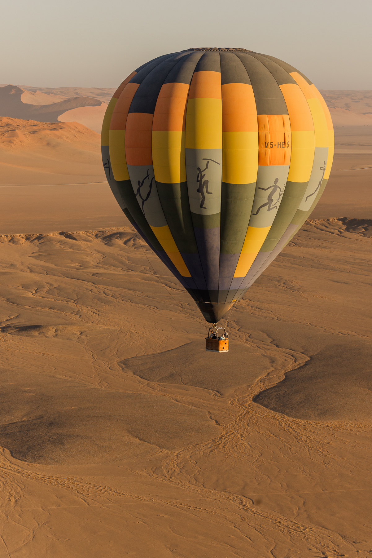 Hot-air balloon drifting low over the dunes of the Namib Desert near Sossusvlei
