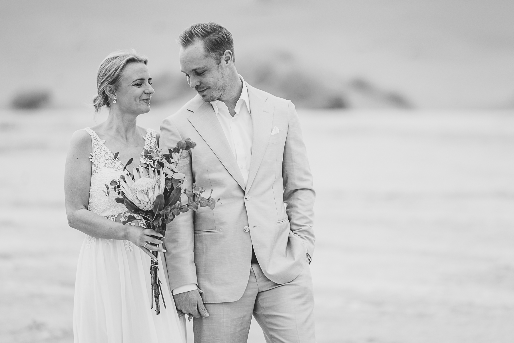 black and white image of couple walking in deadvlei, namibia during sosusvlei elopement