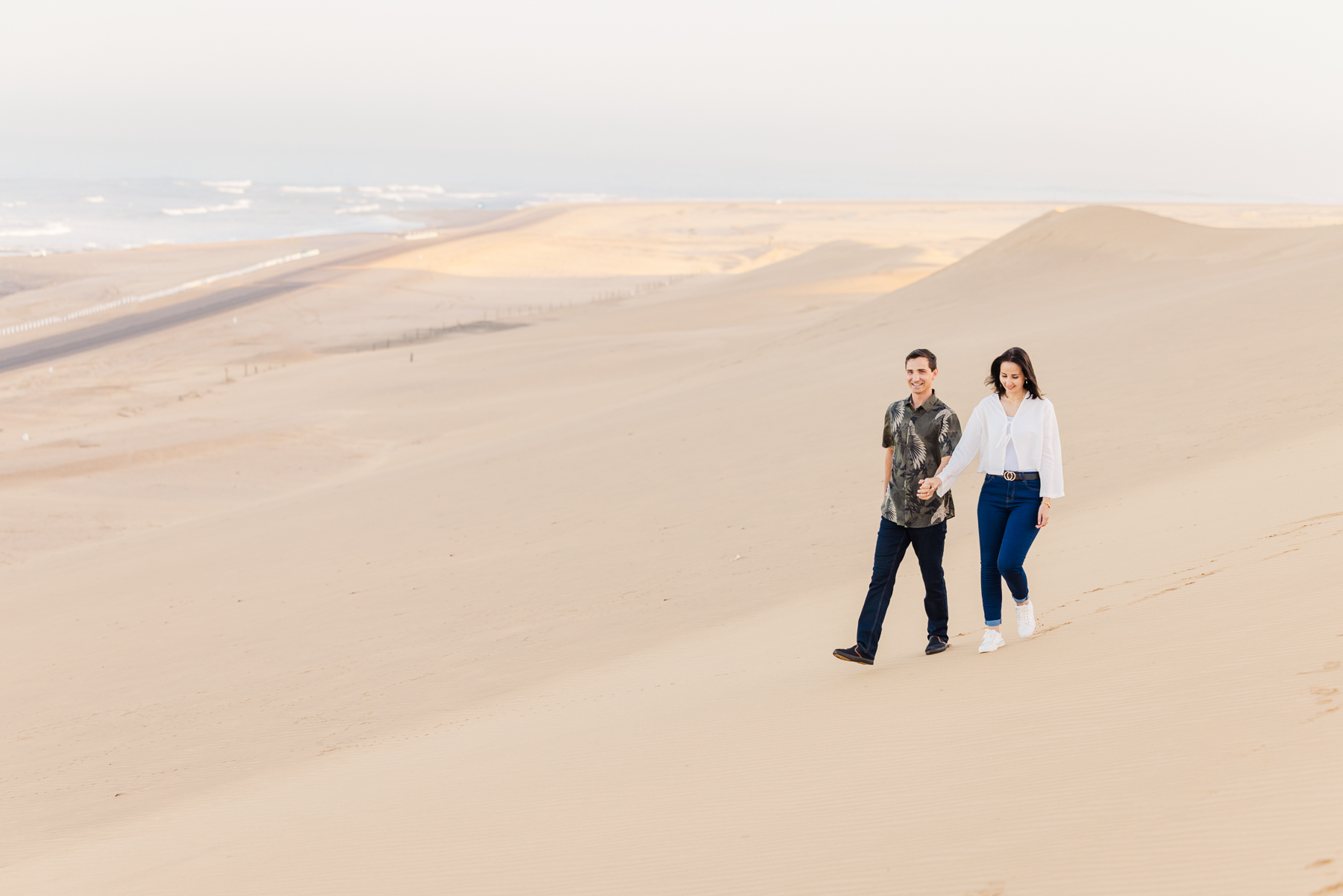 couple walking in dunes in skeleton coast, namibia