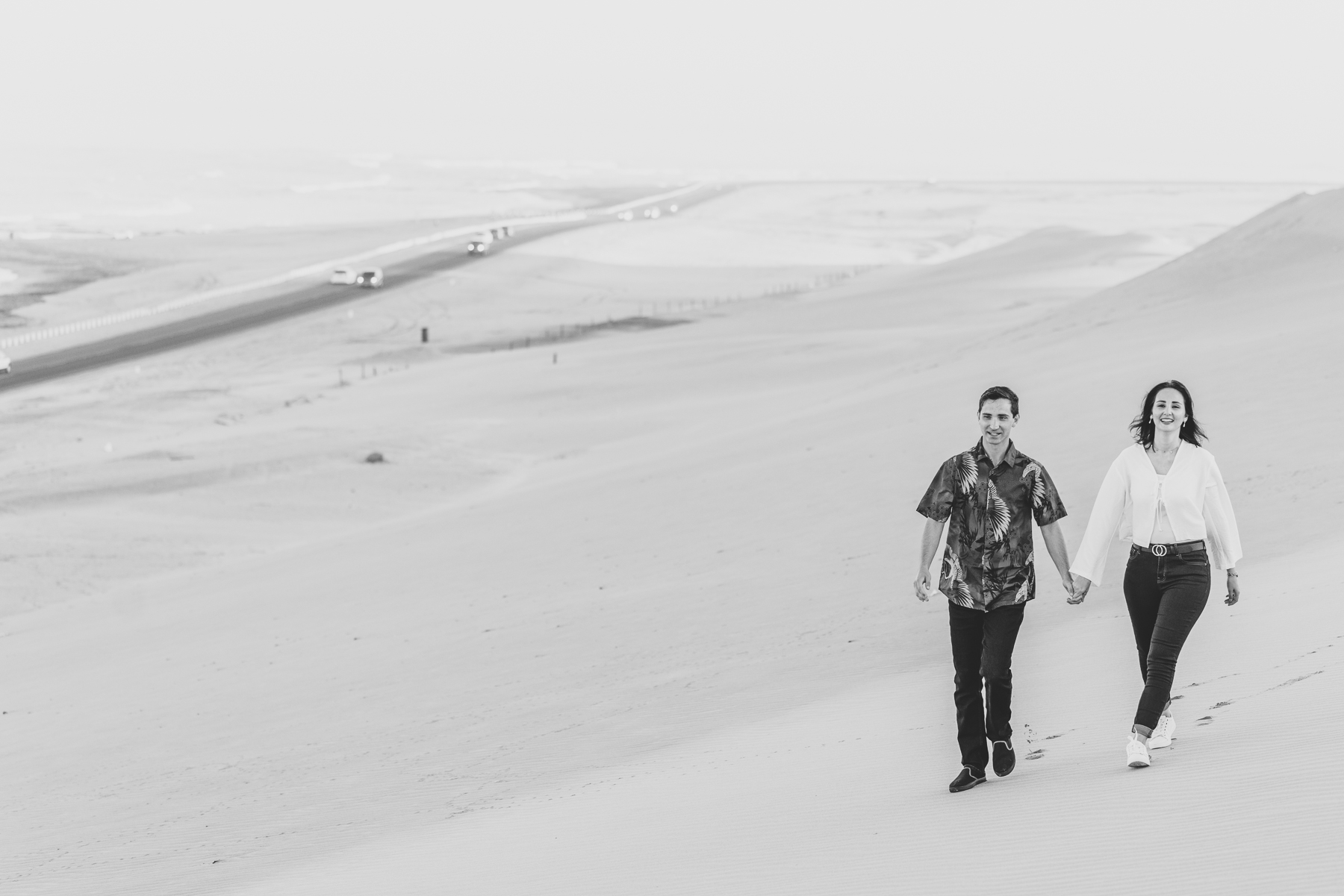 couple walking along dune belt
