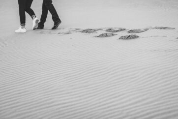 couple walking in sand patterns