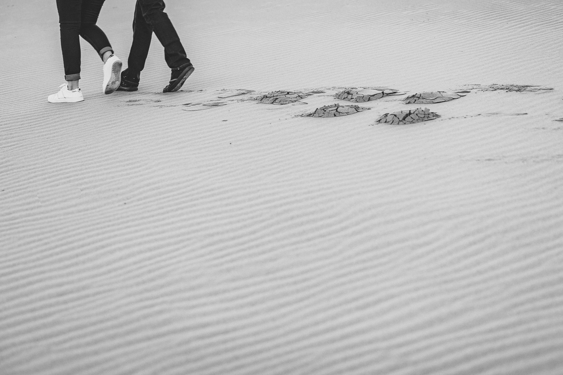 couple walking in sand patterns