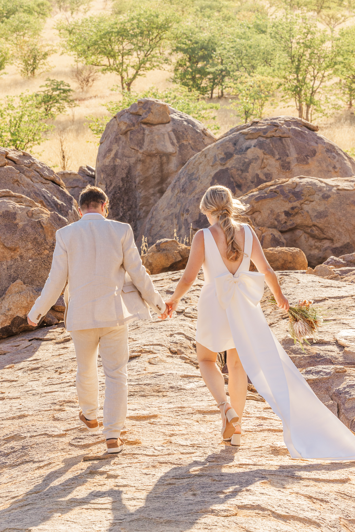 Couple walking hand in hand among the granite boulders of Damaraland