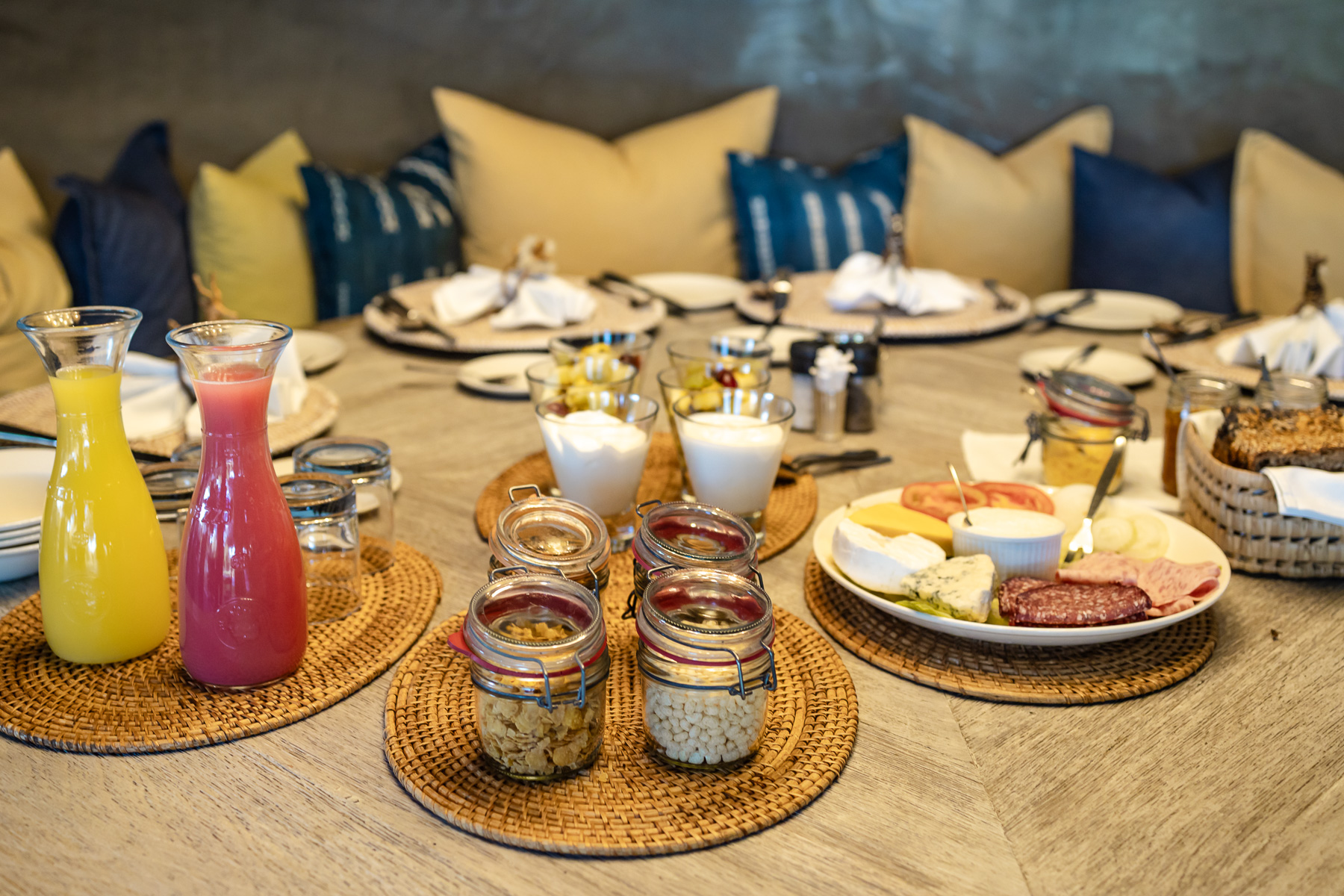 Breakfast table at Mushara Bush Camp with fresh juice, yoghurt, cold meats and cheese