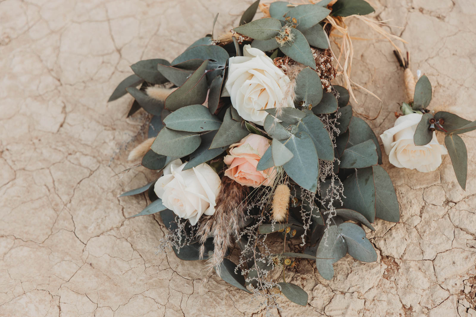 Bridal bouquet of white roses and eucalyptus on the cracked clay of Deadvlei