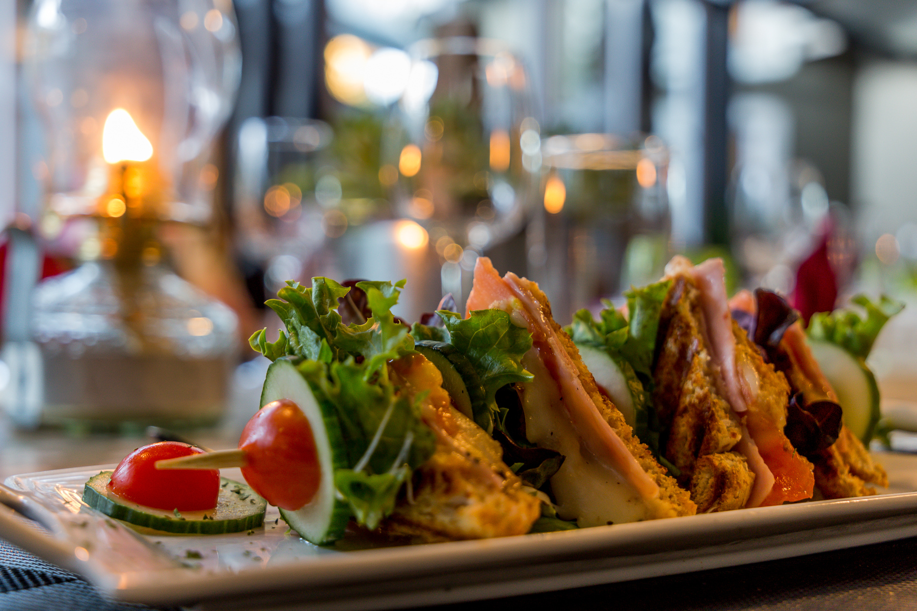 Plated club sandwich with salad by candlelight at The Village Boutique Hotel, Swakopmund
